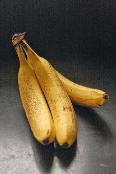 three ripe bananas sitting on top of a table