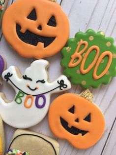 decorated halloween cookies on a white table with pumpkins and jack - o'- lanterns