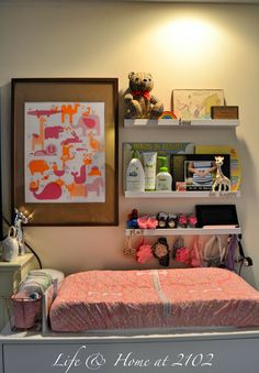 there is a bed in the room with shelves on the wall above it and a baby's crib