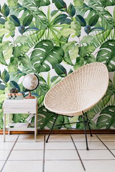 a chair and table in front of a tropical wallpaper