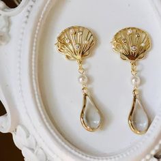 Discover the elegance of our shell earrings, Crafted from gold and adorned with pearls, these teardrop earrings feature a vintage, sophisticated design. Perfect for adding timeless charm and unique style to any outfit. Enhance your look with our handcrafted vintage jewelry. The combination of gold, pearls, and shell creates a unique and sophisticated design. Perfect for any occasion and timeless elegance. Embrace unique style with our elegant teardrop earrings. These earrings blend vintage charm Elegant Shell-shaped Clip-on Earrings For Gift, Elegant Shell-shaped Clip-on Earrings As Gift, Gold Shell-shaped Earrings For Wedding, Gold Pearl Shell-shaped Earrings, Gold Pear-shaped Pearl Teardrop Earrings, Gold Pearl Teardrop Dangle Earrings, Pearl Drop Clip-on Earrings, Gold Pearl Drop Clip-on Earrings, Shell-shaped Pearl Earrings For Wedding