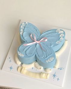 a blue butterfly cake sitting on top of a white plate