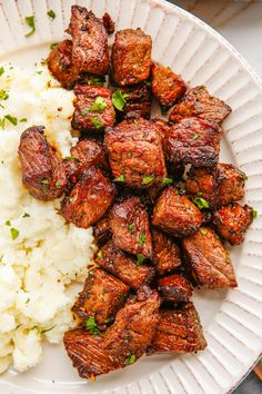 a white plate topped with meat and rice