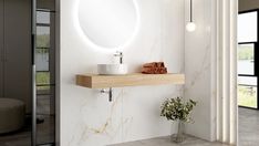 a bathroom with a sink, mirror and vase on the counter top next to it