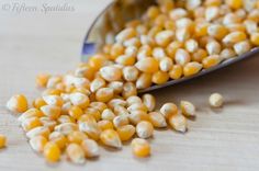 a spoon full of corn sitting on top of a table