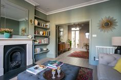 a living room filled with furniture and a fire place in front of a mirror on the wall