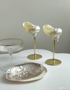 there are two wine glasses and a bowl on the table with one glass in it