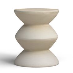 a white vase sitting on top of a table