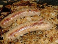 two sausages are being cooked in a skillet with onions and grated meat