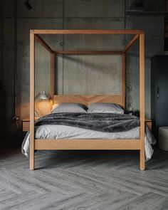 a bed with a wooden frame and headboard is shown in an industrial bedroom setting