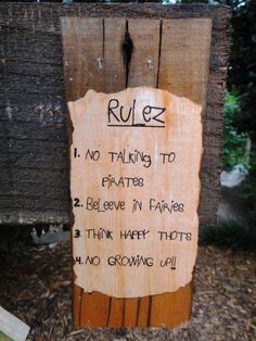 a sign posted on a wooden post that says rules