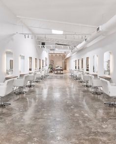 the interior of a salon with chairs and mirrors