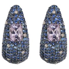 Introducing our Victorian 8.00 Cttw. Blue Sapphire, Spinel, and Diamond Hook Stud Earrings – a captivating fusion of elegance and sophistication. These stunning stud earrings boast a unique curved design, adorned with a dazzling array of round blue sapphires meticulously set in black prongs. The sapphires cascade along the front of the earrings, interspersed with shimmering diamonds that add an extra layer of sparkle and brilliance to the piece. At the heart of each earring lies a mesmerizing cu Luxury Tanzanite Earrings, Blue Pave Set Earrings For Formal Occasions, Formal Blue Pave Set Earrings, Blue Multi-stone Cubic Zirconia Earrings, Blue Cubic Zirconia Earrings With Pave Setting, Everyday Accessories, Natural Blue Sapphire, Black Rhodium, 1 Carat