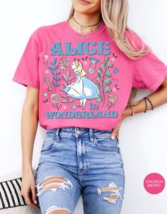 Step into the whimsical world of Wonderland with our Vintage Alice in Wonderland Tee! This charming t-shirt features classic imagery from the beloved tale, capturing the essence of curiosity and adventure. Made with soft, high-quality cotton, it's perfect for adding a touch of nostalgia to your wardrobe. Join Alice on her journey through the looking glass and let your imagination run wild with this enchanting tee! Disney Crew Neck T-shirt With Funny Print, Pink Themed Crew Neck Tops, Disney Cotton T-shirt For Spring, Pink Crew Neck Themed Tops, Disney Character Print T-shirt For Spring, Themed Pink T-shirt With Graphic Print, Themed Graphic Print Pink T-shirt, Whimsical Cotton Short Sleeve Tops, Vintage Alice In Wonderland