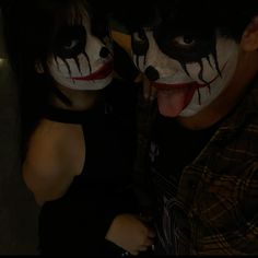 two people with painted faces posing for the camera