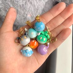 a hand holding a bunch of colorful beads on it's thumb and keychain