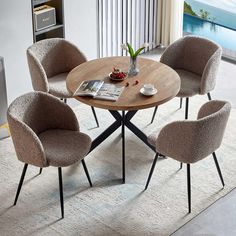 a table with four chairs around it and a magazine on the table next to it