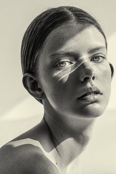 a black and white photo of a woman with freckles on her face