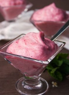 two small bowls filled with ice cream on top of a wooden table