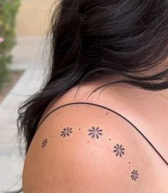 the back of a woman's shoulder with small flowers on her left arm and chest