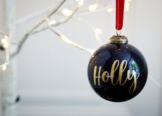 a christmas ornament hanging from a tree with lights on it's branches