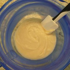 a blue bowl filled with batter and a white spatula