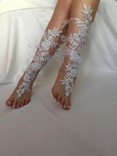 a woman's legs with white lace and flowers on them