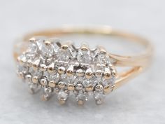 a gold and white diamond ring sitting on top of a table