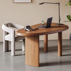 a table with a laptop on it next to two chairs and a potted plant