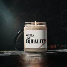 a candle sitting on top of a table with the words smells like equality printed on it