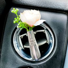 a car air vent with a flower in the center piece and an emblem on it