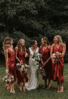 a group of women standing next to each other on top of a lush green field