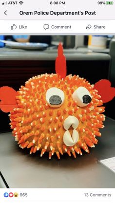 an orange and white toy with eyes and ears on it's head, sitting on top of a table