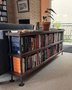 a living room with a book shelf filled with books and a couch in the background