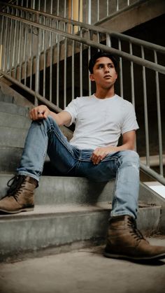 a man is sitting on the stairs with his legs crossed