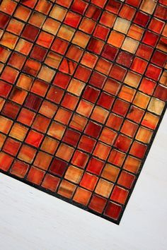 an orange and yellow mosaic tile on a white surface