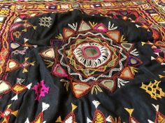 an intricately designed black cloth with multicolored designs