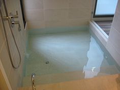 a bathroom with a glass shower stall and tiled walls