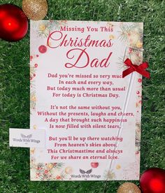 a christmas card on the grass with ornaments around it and a message written in red