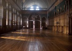 an empty hall with wooden floors and high ceilings