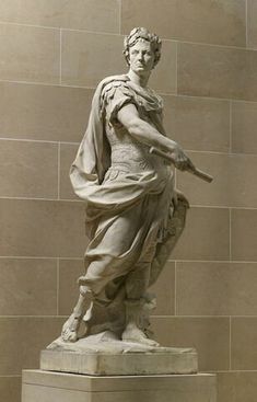 a statue of a man holding a baseball bat in his right hand and standing next to a wall