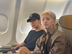 two young men sitting on an airplane seat