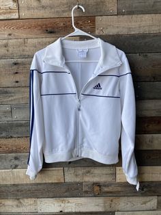 Sweet Adidas jacket! Features Include... Adidas track jacket White with navy blue stripes and embroidered logo "The Brand With the Three Stripes" Zip front Made by Adidas Tag size USA medium (please see measurements below for most accurate sizing) Condition... Excellent vintage condition - no holes, flaws or other issues. Jacket is clean and ready to wear! Measurements... Shoulder to shoulder - 15"  Sleeve length - 24" Around chest, underneath armpits - 38 1/2"  Waist - 36 1/2" with elastic for Spring White Outerwear With Contrast Stripes, White Track Jacket With Three Stripes, Fitted Long Sleeve Outerwear With Three Stripes, Casual White Track Jacket With Side Stripes, Casual Striped Long Sleeve Track Jacket, Sporty White Outerwear With Contrast Stripes, White Winter Outerwear With Contrast Stripes, White Track Jacket With Contrast Stripes For Winter, White Track Jacket With Three Stripes For Fall