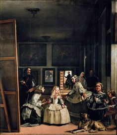 a group of people standing around a painting