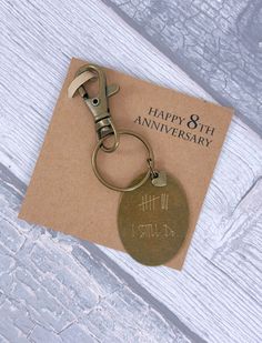 a keychain with a happy 8th anniversary tag attached to it on top of a piece of paper