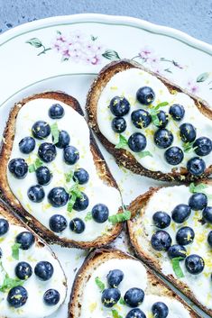 toasted bread with blueberries and yogurt on it sitting on a plate