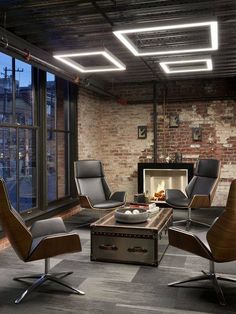 a living room filled with furniture and a fire place next to a brick wall covered in windows