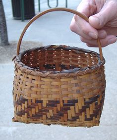 a person holding a woven basket in their hand