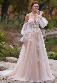 a woman in a wedding dress posing for the camera with her hand on her face