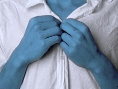 a man with blue hands on his chest